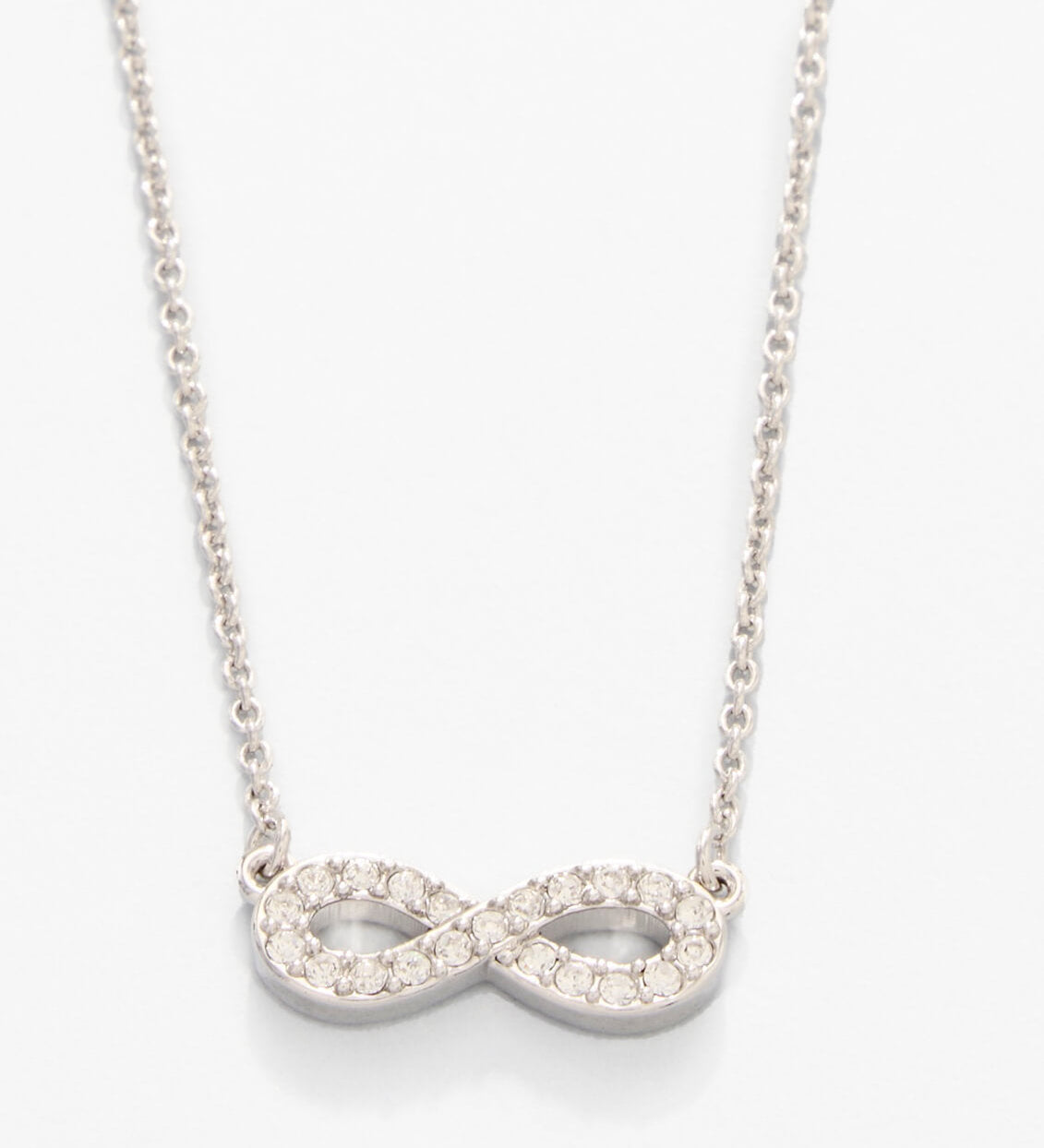 Silver infinity necklace with clear stones on a white background. Available at Be Charmed