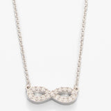 Silver infinity necklace with clear stones on a white background. Available at Be Charmed