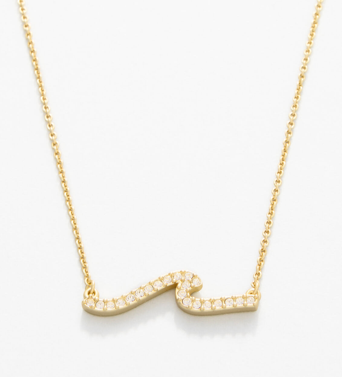 Gold necklace with a wavy design on a white background. Available at Be Charmed