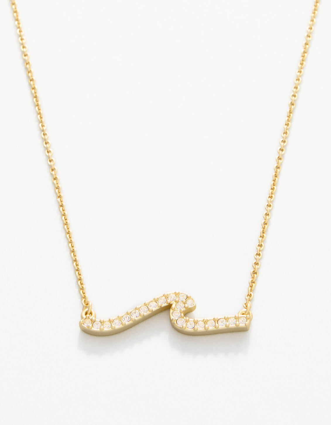 Gold necklace with a wavy design on a white background. Available at Be Charmed