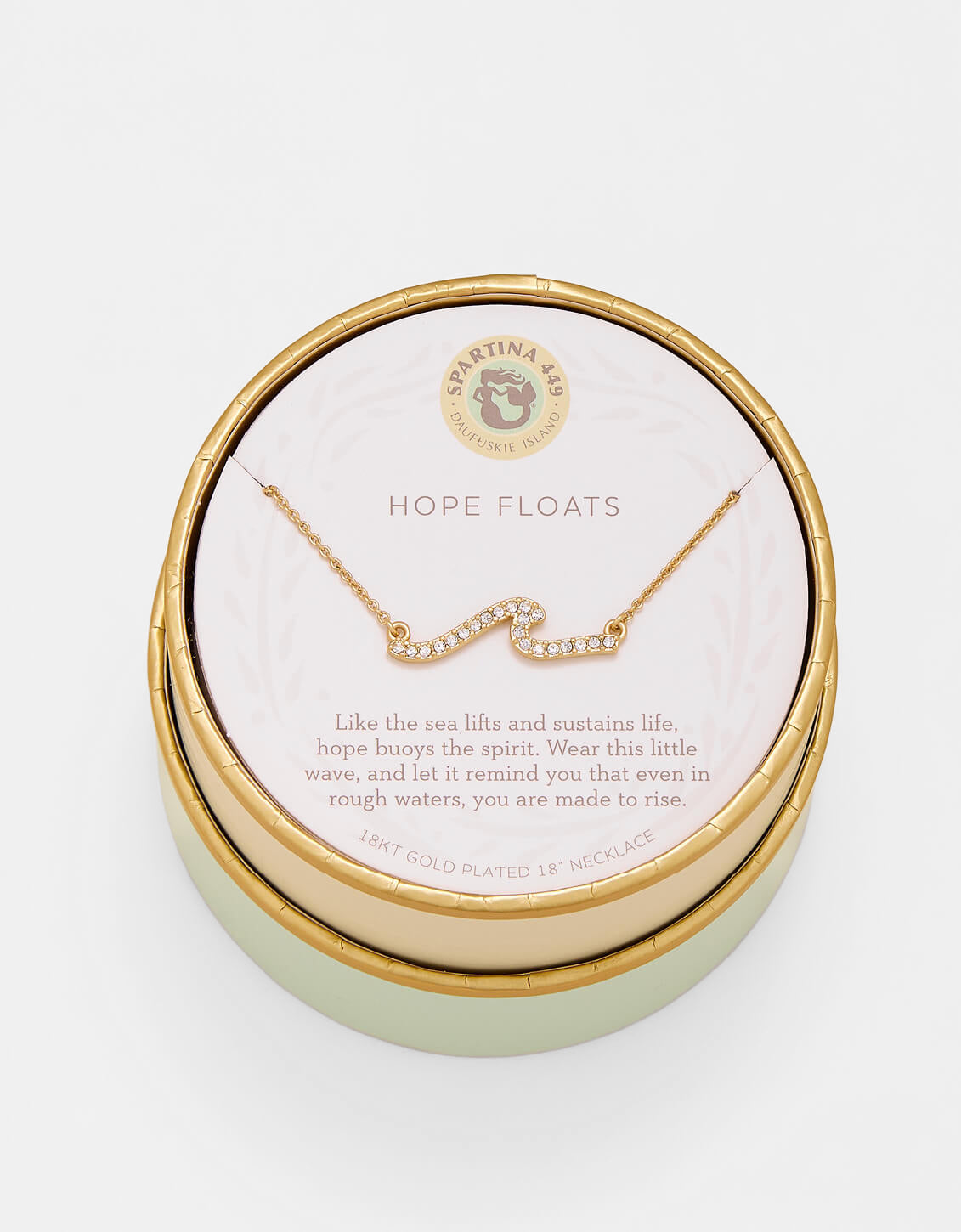 Gold necklace in a round jewelry box with 'Hope Floats' text on a light background. Available at Be Charmed
