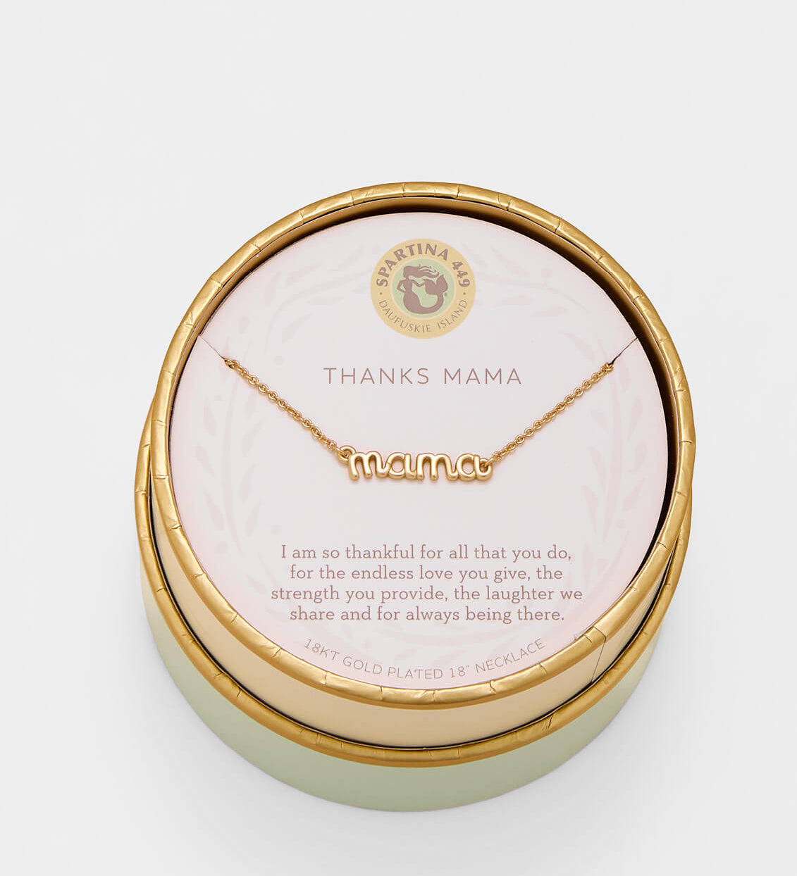 Gold 'mama' necklace in a round box with a message card on a light gray background. Available at Be Chamred