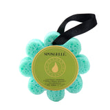 A flower-shaped bath sponge with a pattern of dots, predominantly blue with a black hanging ribbon and a label in the center that reads 'Spongellé - Coconut Verbena'. Available at Be Charmed