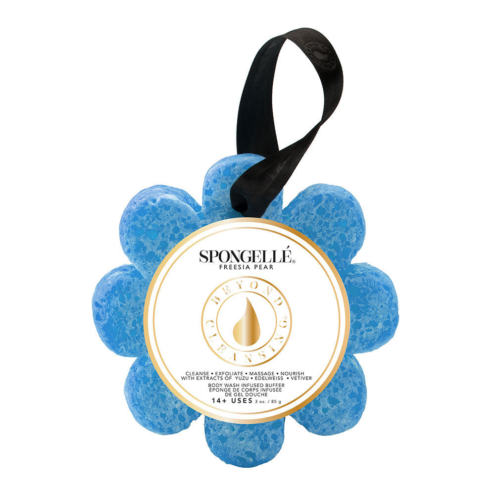 A blue flower-shaped Spongellé bath sponge with a black hanging ribbon, branded with a gold and white label. Available at Be Charmed