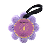 A purple bath sponge with a flower-like shape, labeled Spongellé with the word 'Wild Flower' and 'French Lavender'. There is a black string attached for hanging. Available at Be Charmed
