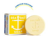 A bar of soap with a yellow label that reads 'Sea Salt' and 'Limited Edition'. The background has a blue and white design with text that reads 'SWEDISH DREAM SOAP'. Available at Be Charmed