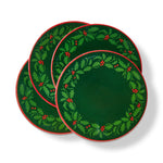 A set of four enamel-decorated holiday beverage coasters featuring a classic green holly wreath motif, available at Be Charmed.