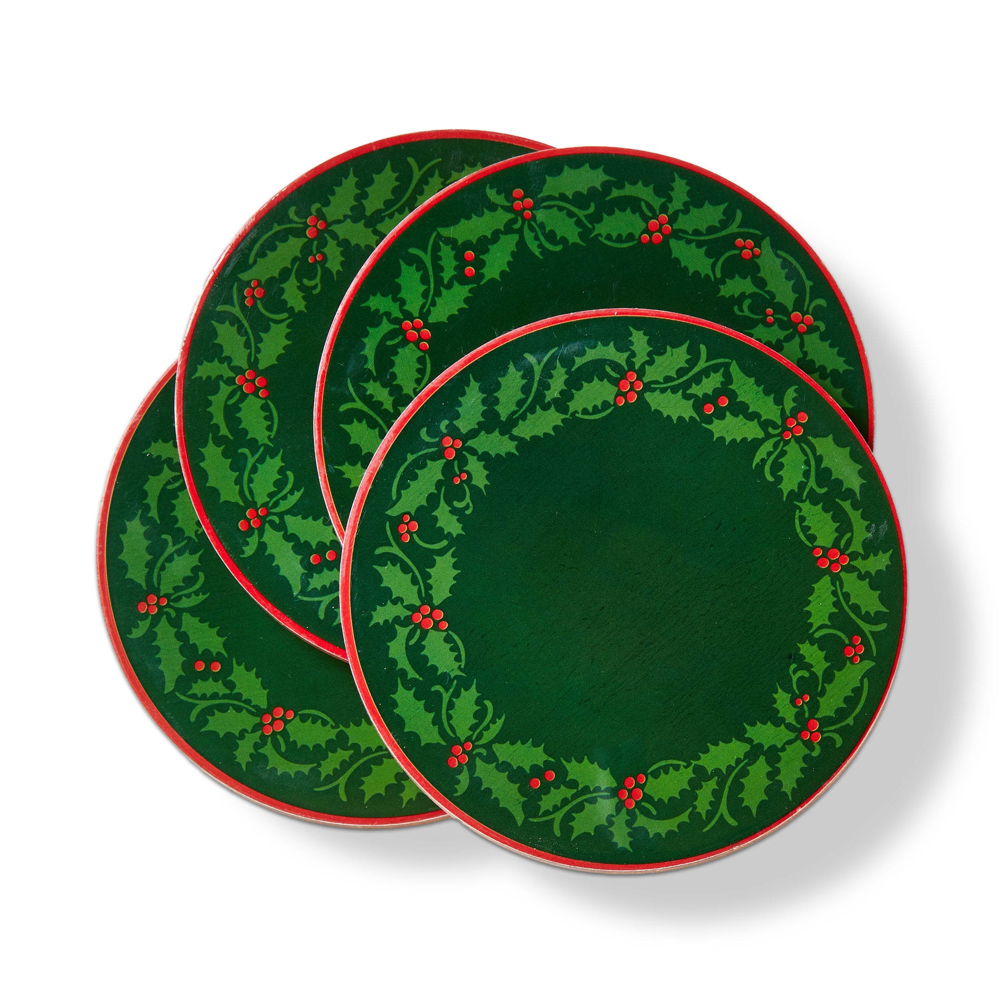 A set of four enamel-decorated holiday beverage coasters featuring a classic green holly wreath motif, available at Be Charmed.