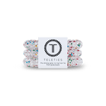 Pack of three Teleties hair ties with a label that reads 'the strong grip, no rip hair tie that doubles as a bracelet. Strong, pretty and stylish. Available at Be Charmed