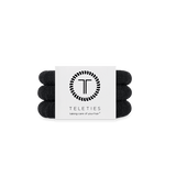 Set of jet black hair ties with a Teleties branded card on a white background. Available at Be Charmed
