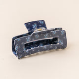 A floral patterned hair claw clip on a light background. Available at Be Charmed