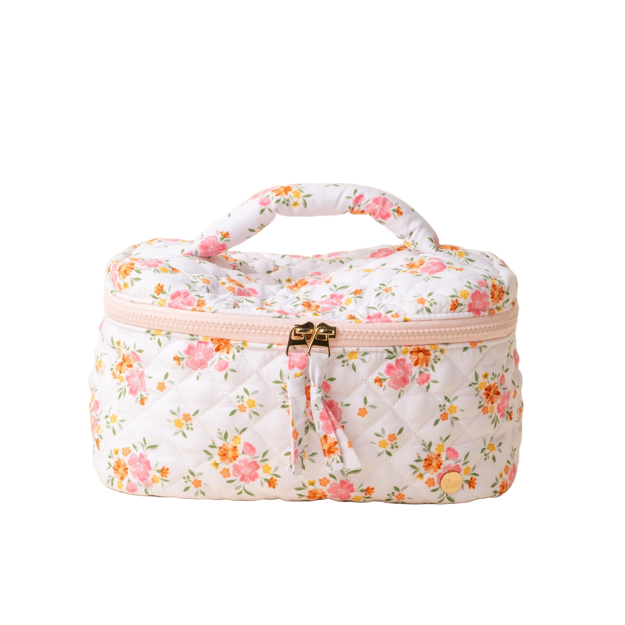 A quilted cosmetic bag with a floral pattern, a pink handle, and a double gold zipper. Available at Be Charmed