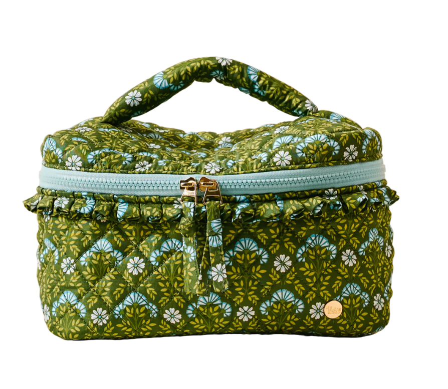 Green floral-patterned cosmetic bag with a gold zipper on a beige background. Available at Be Charmed