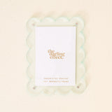 A pale blue mini acrylic picture frame with a scalloped border and the brand 'the darling effect' printed at the bottom. Available at Be Charmed