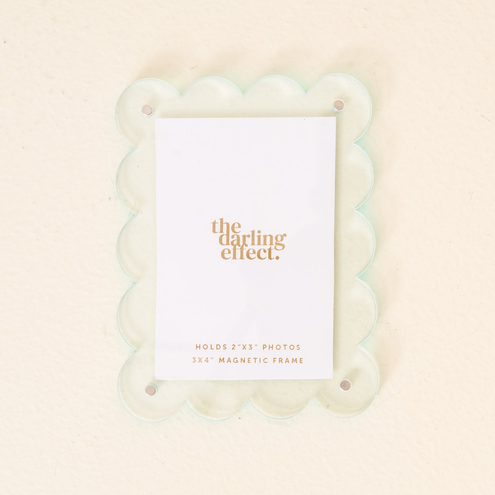 A pale blue mini acrylic picture frame with a scalloped border and the brand 'the darling effect' printed at the bottom. Available at Be Charmed