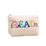 White fleece pouch with colorful 'READ' text on a beige background. Availablea at Be Charmed