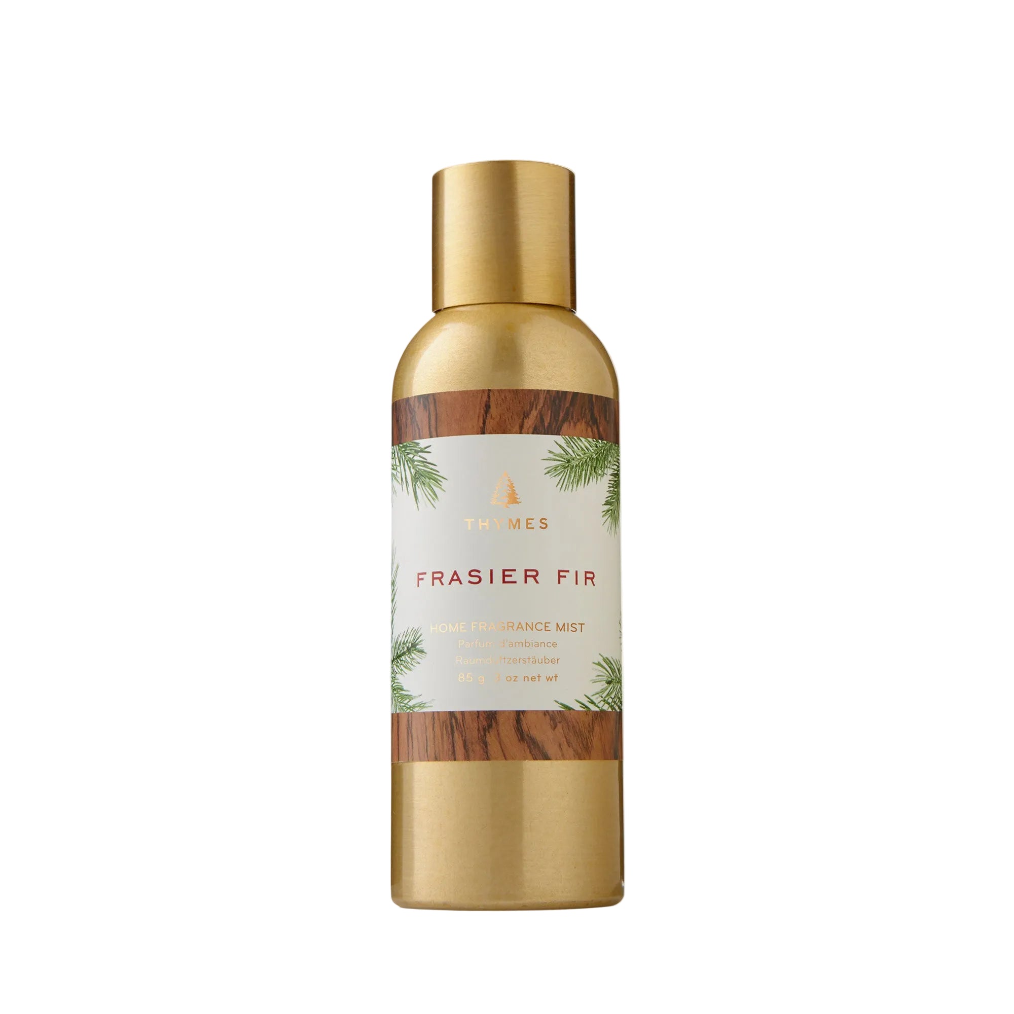 A bottle of Thymes Frasier Fir Home Fragrance Mist with a gold cap and label featuring green pine needles. Available at Be Charmed