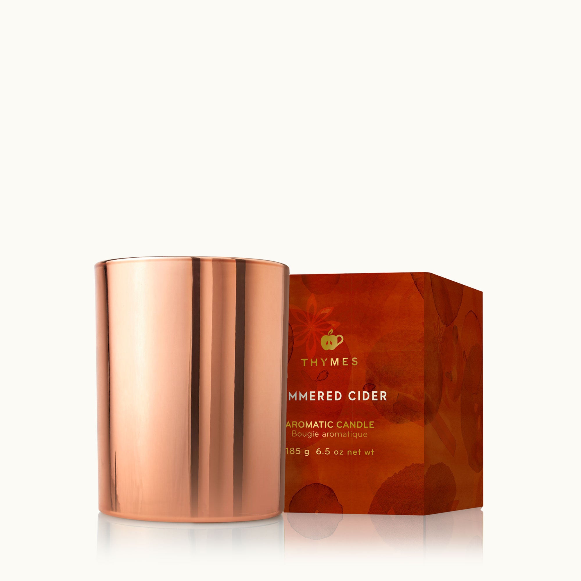 Thymes Simmered Cider 6.5 oz poured tin candle in rose-gold tin with apple, clove & cardamom scent—Available at Be Charmed.