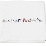 A white cotton kitchen towel with the word 'MASSACHUSETTS' and an illustration that includes a sailboat, a lobster, a crab, and a representation of the state flag. Available at Be Charmed