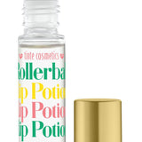 A clear rollerball lip potion bottle labeled 'Birthday Cake' with a colorful label, alongside a gold-colored lid. Available at Be Charmed