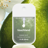 Touchland hand sanitizer power mist with green apple background. Available at Be Charmed.