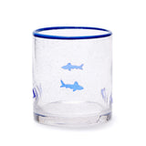 Clear glass tumbler with blue rim and shark illustrations on a white background. Available at Be Charmed