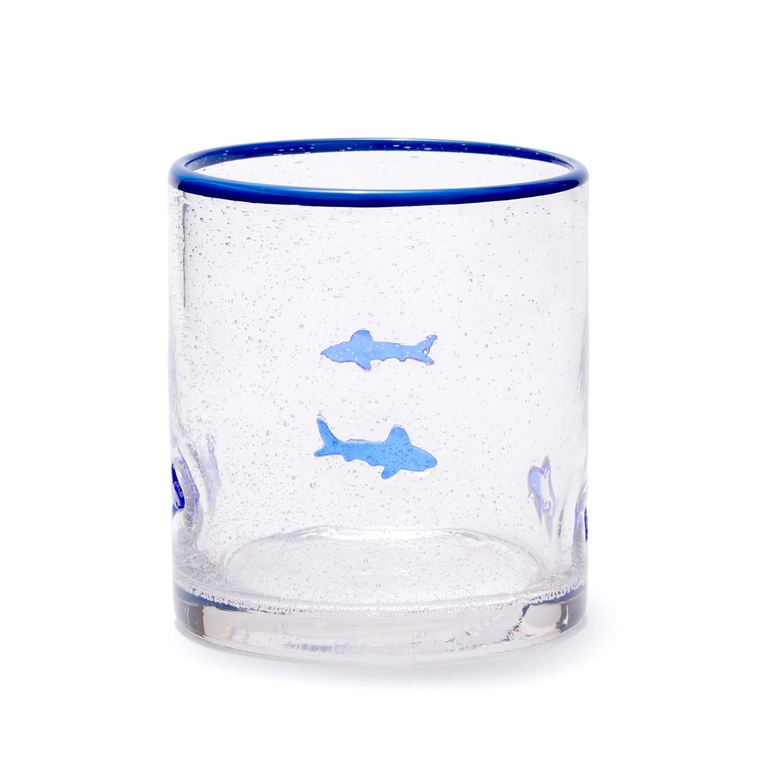 Clear glass tumbler with blue rim and shark illustrations on a white background. Available at Be Charmed
