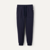 A pair of navy blue UGG men's jogger pants with a drawstring waist and a brand tag on the lower left side. Available at Be Charmed