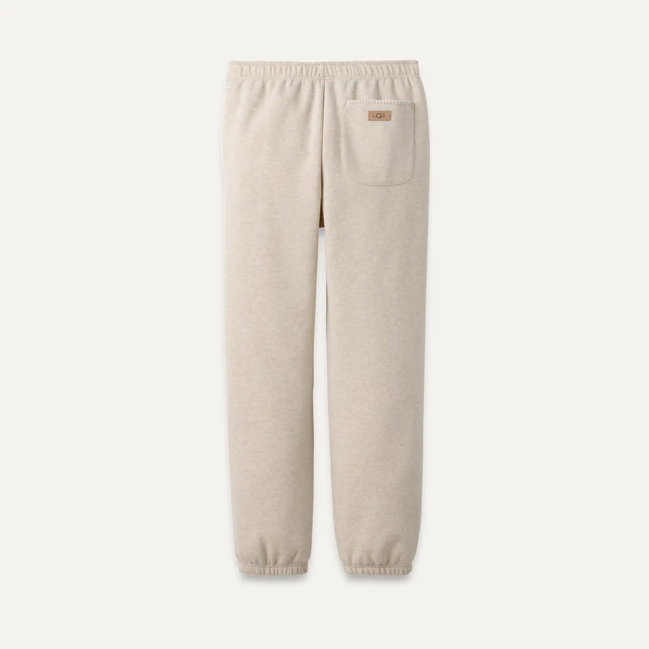 Beige sweatpants with a pocket on a white background. Available at Be Charmed. 
