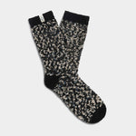 A pair of UGG Women's Cozy Chenille Socks in black, gray, and white colors. Available at Be Charmed. 
