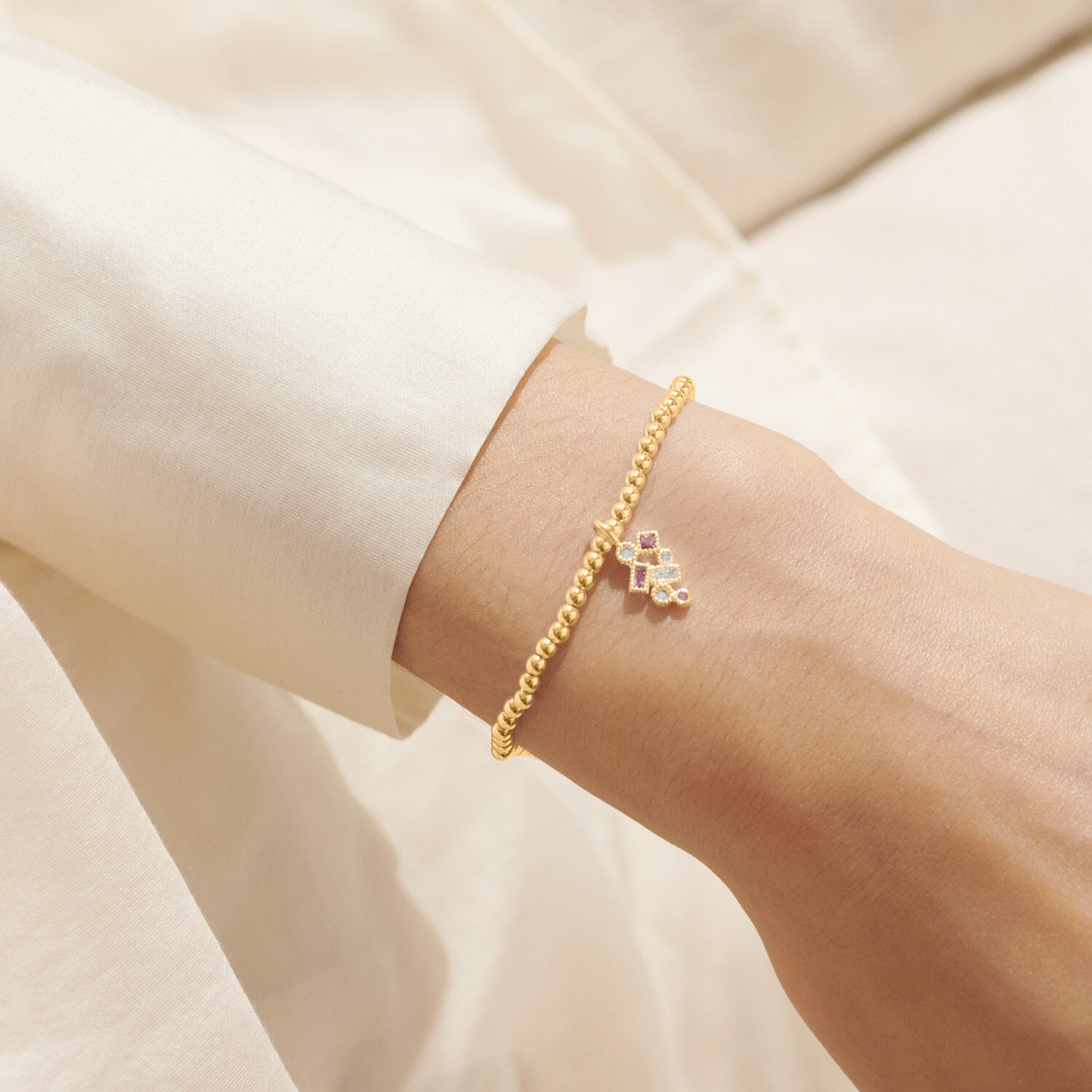 Woman wearing A Littles & Co Happiest of Birthdays Gold Bracelet—elegant gold charm bracelet with sweet birthday sentiment, perfect gift from Be Charmed. 