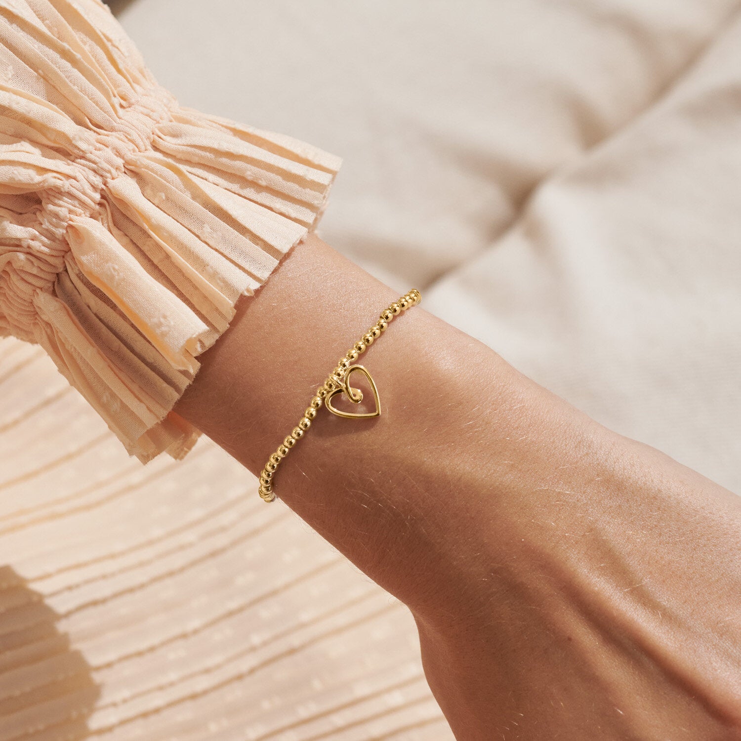Woman Wearing A Littles & Co Lucky to Have a Sister Like You Gold Bracelet—delicate charm design with heartfelt sentiment, perfect sister gift from Be Charmed.