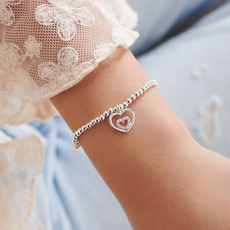 A Littles & Co Kids'Silver Goddaughter Bracelet featuring a sweet silver-plated heart charm on a stretch bead band, a beautiful keepsake gift for special occasions, available at Be Charmed
