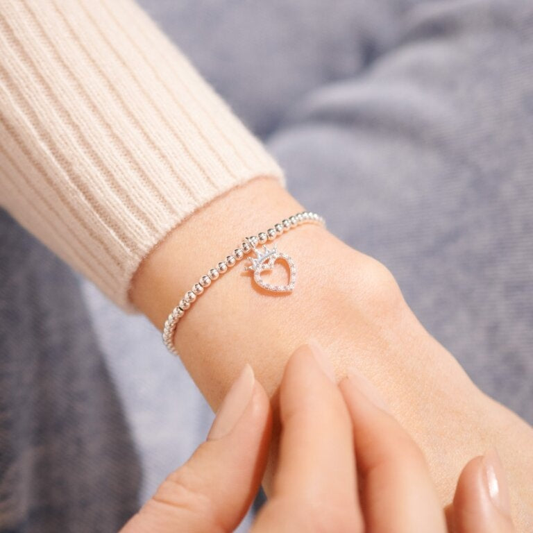 Woman wearing A Littles & Co Silver Birthday Queen Bracelet with a delicate charm design—perfect for celebrating her special day in style, from Be Charmed.