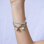 Woman weaking Emma Silver Paper Airplanes Bracelet by Calico Sun—a delicate silver link chain featuring tiny paper airplane charms, whimsical and lovely, available at Be Charmed.
