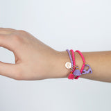 Child wearing  Zoey Cat Bracelet by Calico Sun—a fun adjustable cord bracelet with colorful enamel cat charm, perfect for kids and tween style, available at Be Charmed.
