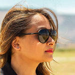 Woman wearing Operation Blackout Goodr sunglasses with all-black polarized lenses and matte black no-slip frames—sleek performance shades; available at Be Charmed