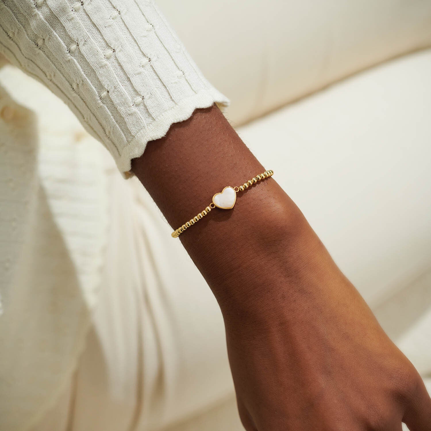 Woman wearing a Marvelous Mom gold bracelet by A Littles & Co, gold-tone stretch charm bracelet. Available at Be Charmed.