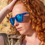 Woman wearing Goodr Falkor's Fever Dream Sunglasses featuring blue on blue frames and polarized lenses, inspired by whimsical fantasy and built for comfort, available at Be Charmed
