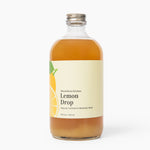 Bottle of Lemon Drop syrup with a label on a white background. Available at Be Charmed
