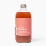 Bottle of Paloma grapefruit and lime cocktail mix on a white background. Available at Be Charmed