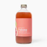 Bottle of Paloma grapefruit and lime cocktail mix on a white background. Available at Be Charmed