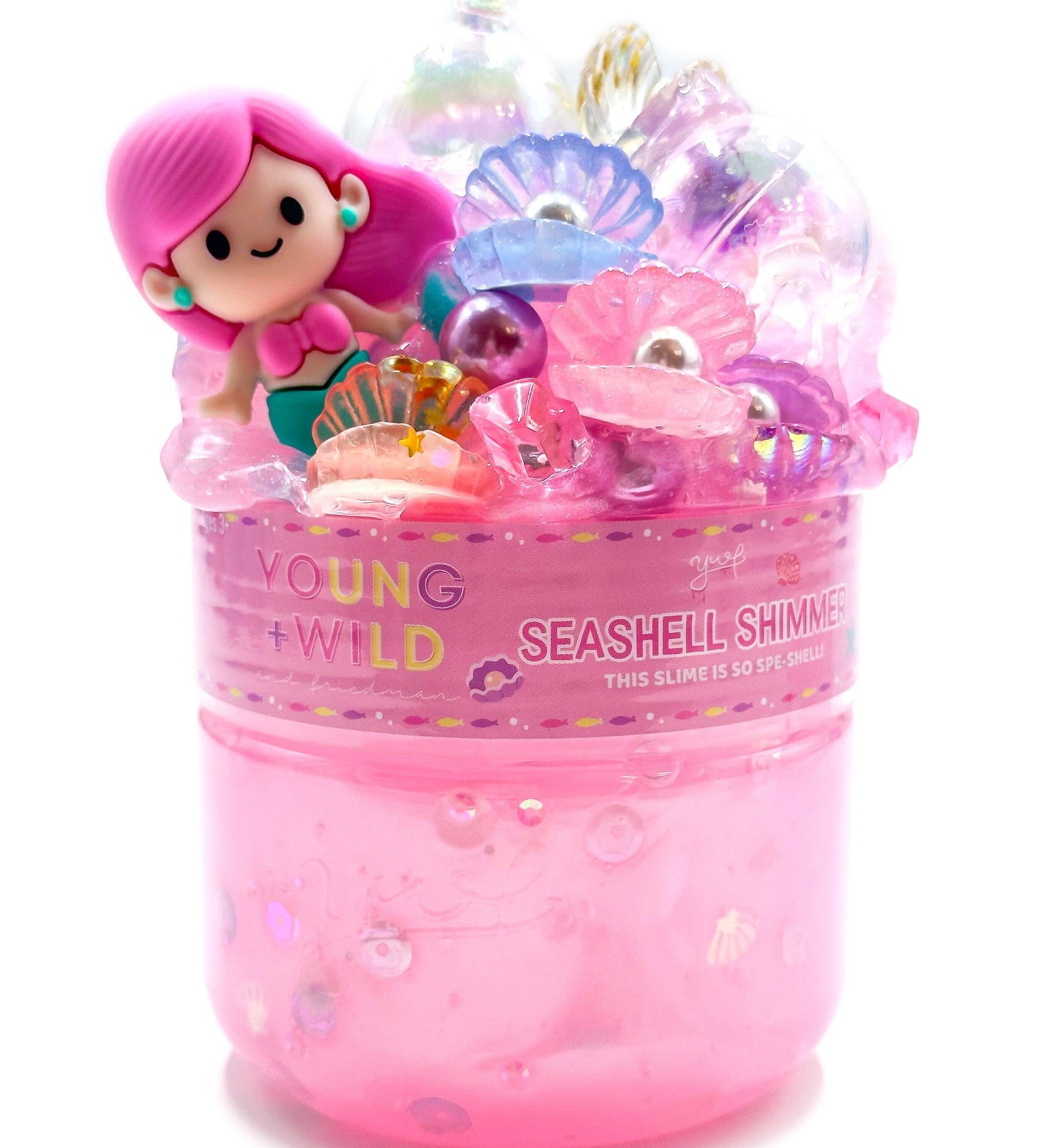 A container of Seashell Shimmer vibrant, non-sticky sensory play slime with themed miniature mix-in trinkets, available at Be Charmed.  