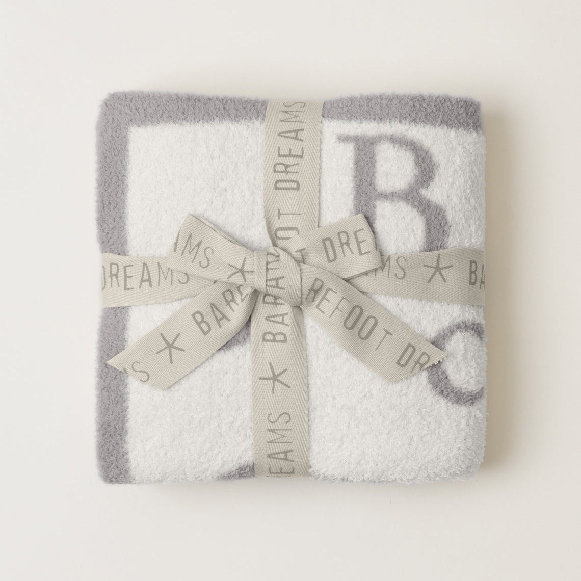 Barefoot Dreams Oyster/Cream CozyChic ABC Blanket tied with Gray Ribbon