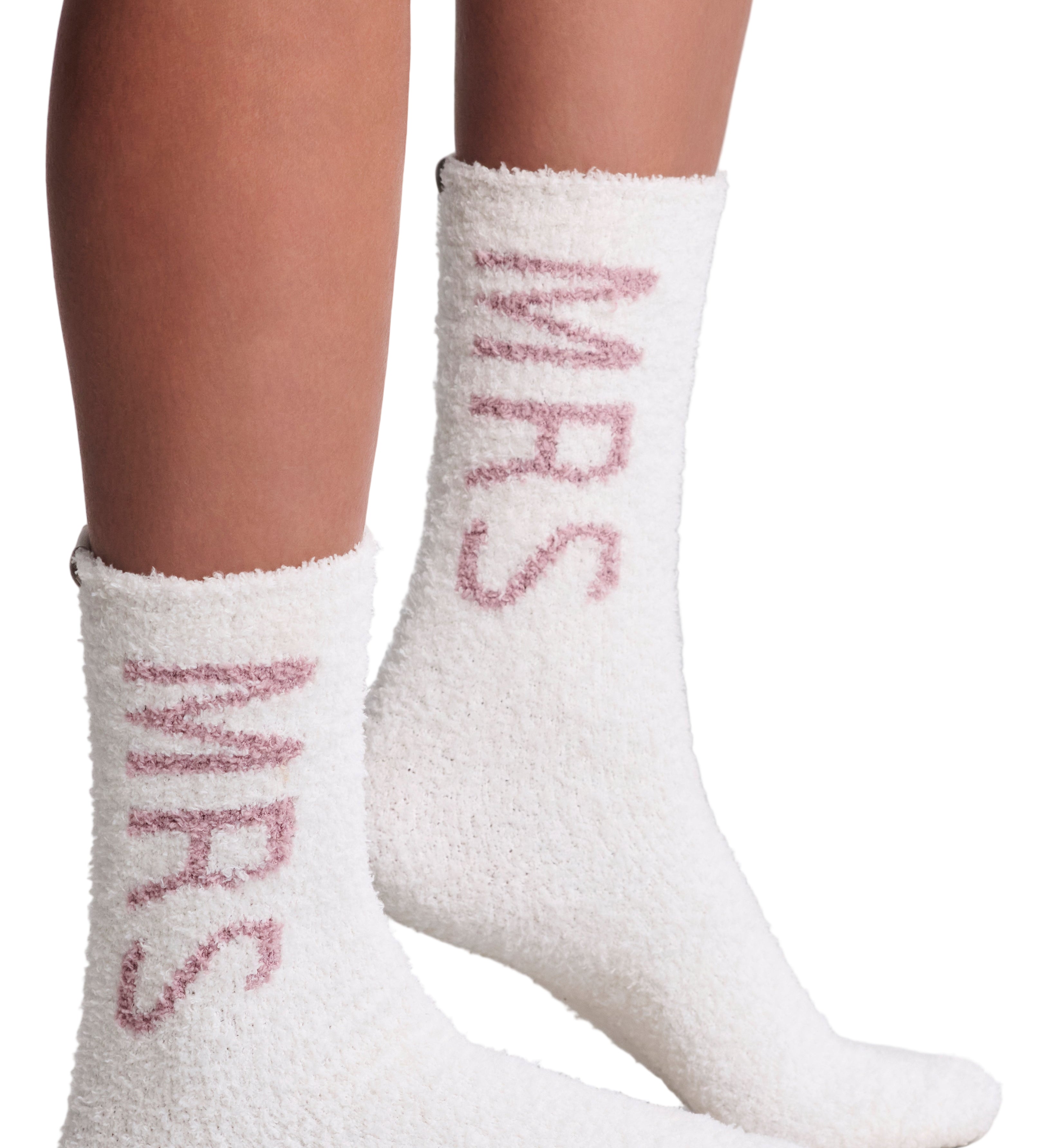 White fuzzy socks with pink Mrs text worn by a person on a light gray background. Mrs Wedding fuzzy socks. Available at Be Charmed. 