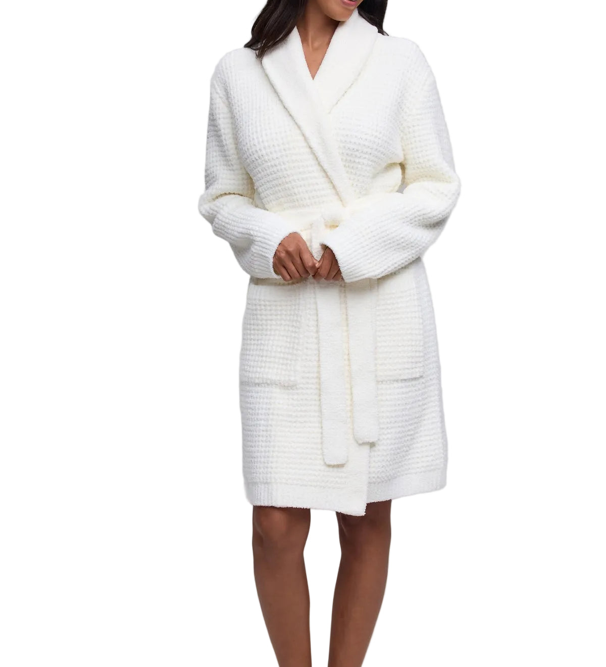 A woman modeling a pearl Barefoot Dreams  textured waffle-knit bathrobe against a white studio background.