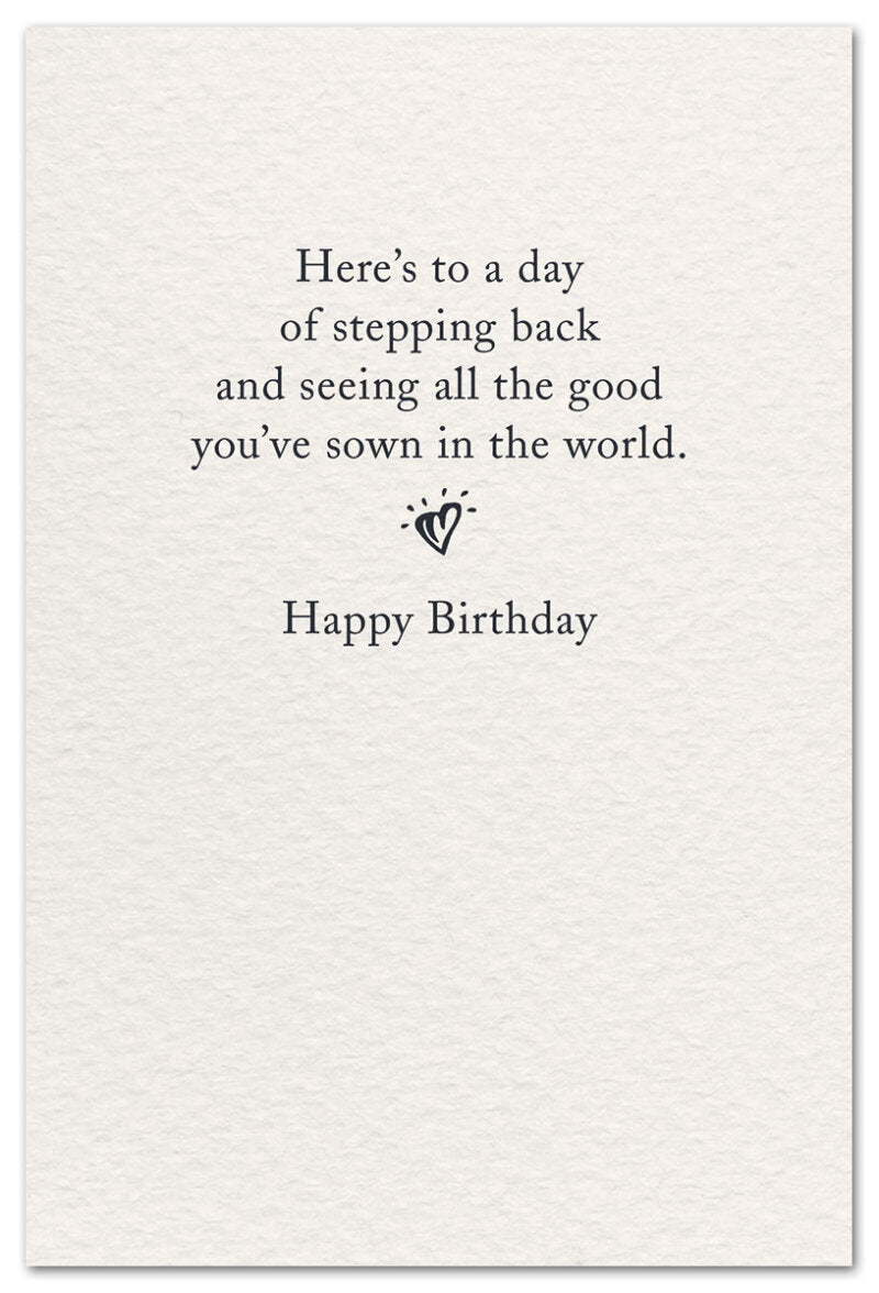 Inside reads “Here’s to a day of stepping back and seeing all the good you’ve sown in the world.” with a small heart and “Happy Birthday.” Available at Be Charmed.