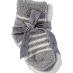 Gray and white striped infant Barefoot Dreams socks with a bow on a beige background. Available at Be Charmed