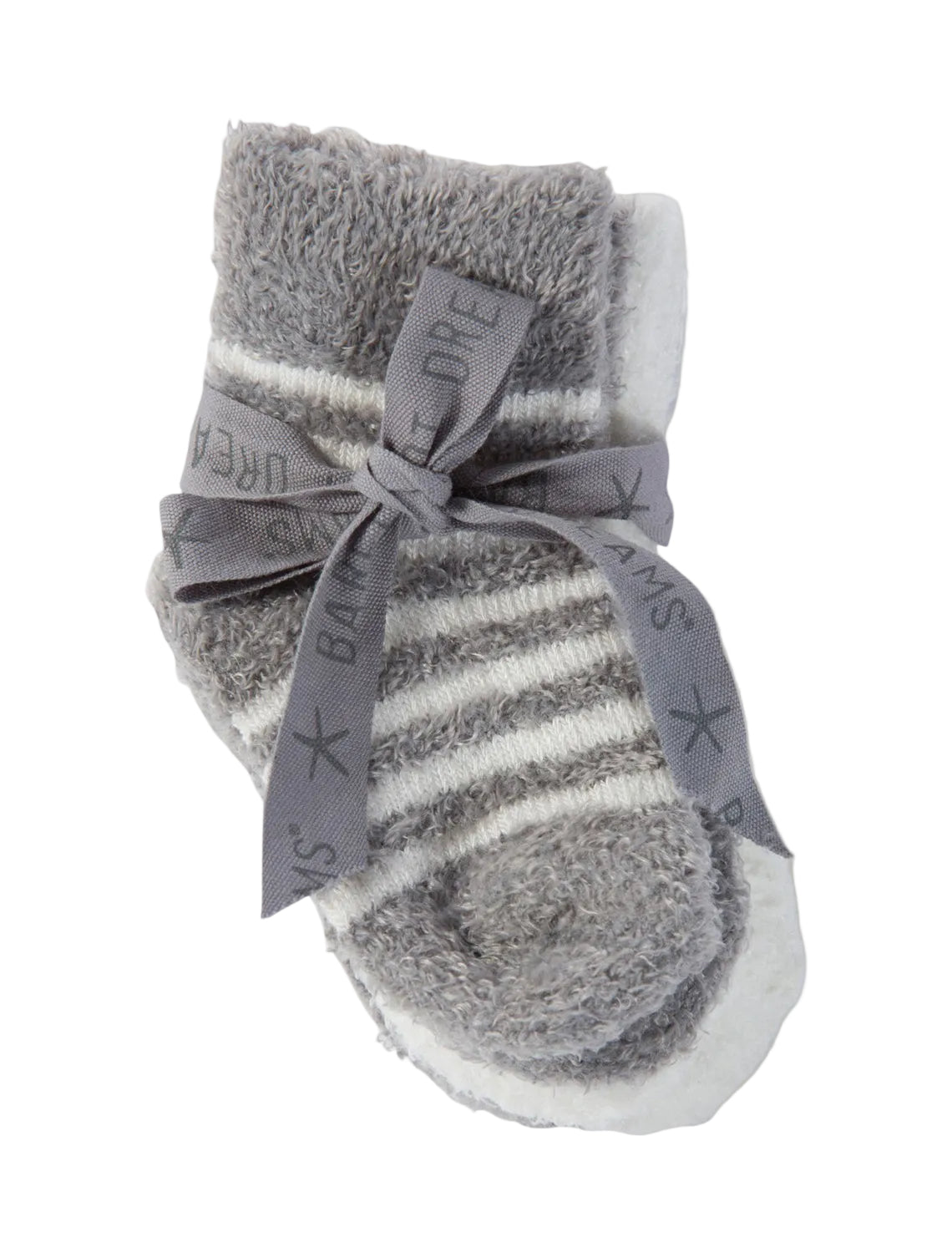 Gray and white striped infant Barefoot Dreams socks with a bow on a beige background. Available at Be Charmed