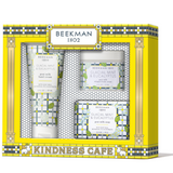Beekman 1802 Kindness Cafe gift set containing four skincare items: goat milk hand cream, glacial mint & eucalyptus hand cream, glacial mint & eucalyptus jar, and goat milk soap, all in a yellow and blue patterned gift box. Available at Be Charmed